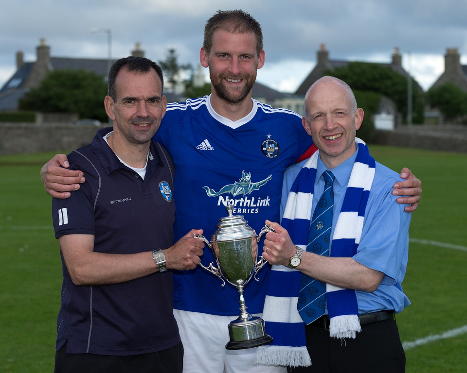 Shetland captain Leighton Flaws, manager Niall Bristow (right) and assistant manager Ian Irvine with the Milne Cup. Photo: Kevin Jones