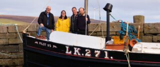 The organising team for Shetland Boat Week aboard the Pilot Us at Hay's Dock in Lerwick. From left: Brian Wishart, Emma Miller (Shetland Amenity Trust), John Henderson (Ocean Kinetics) and Ian Tait (Shetland Museum). Also on the team but missing from the photo is Davy Cooper of Shetland Amenity Trust. Photo: Steven Christie